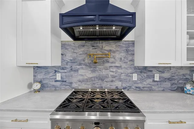 a bathroom with a white bath tub sitting next to a white sink and a mirror