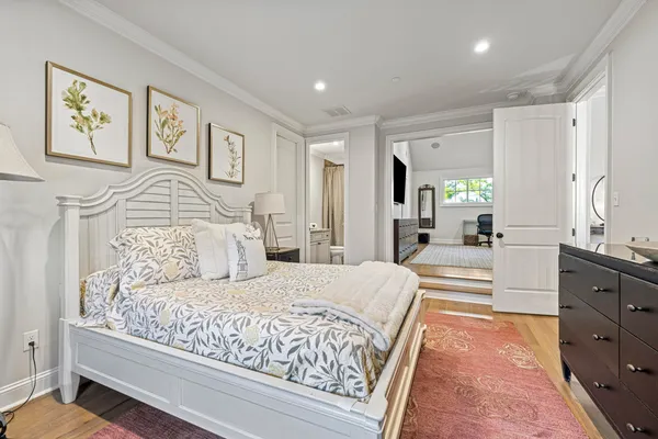 a spacious bedroom with a large bed and a chandelier