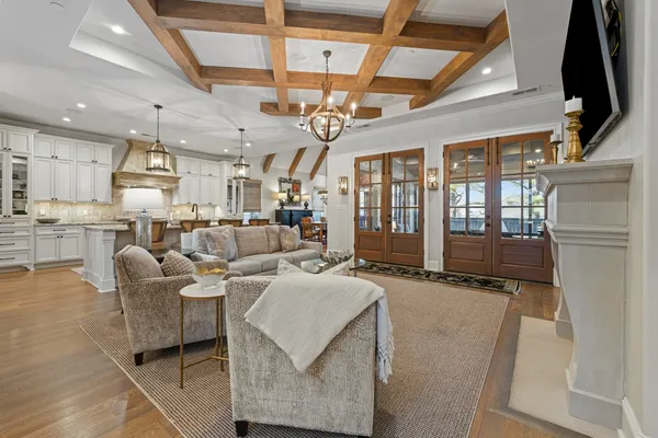 a living room with couches a dining table and chairs with kitchen view