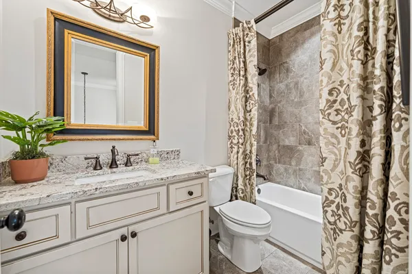 a bathroom with a granite countertop sink toilet a mirror and shower