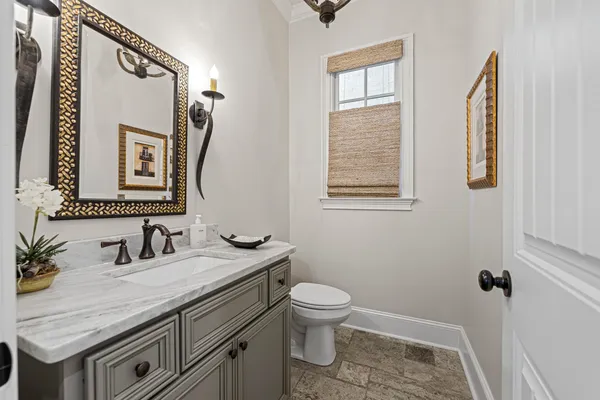 a bathroom with a granite countertop sink mirror vanity and toilet
