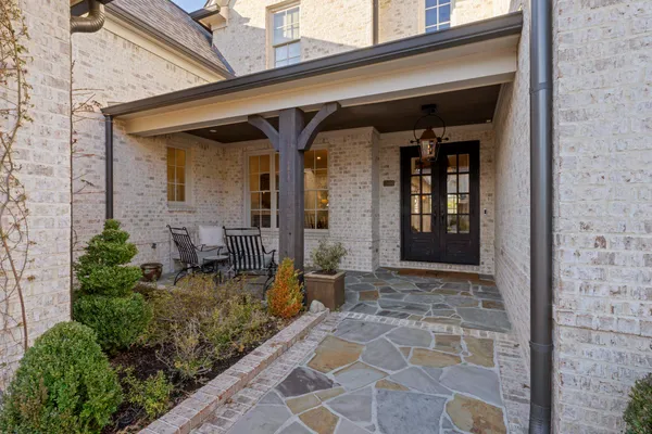 a view of house with patio outdoor seating and plants
