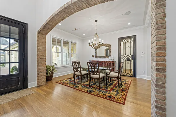 a dining room with furniture a chandelier and wooden floor