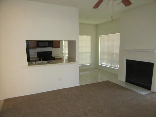 a view of empty room with a fireplace and window