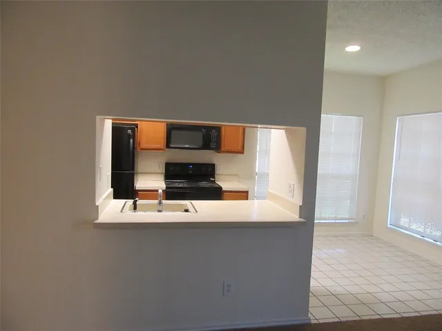 a view of kitchen with stainless steel appliances wooden floor