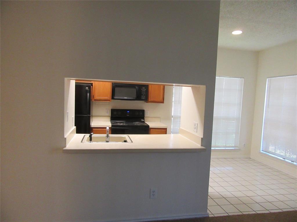 9737 Whitehurst Drive, Unit 39 Dallas, TX 75243 - Photo 3 of 5 a view of kitchen with stainless steel appliances wooden floor