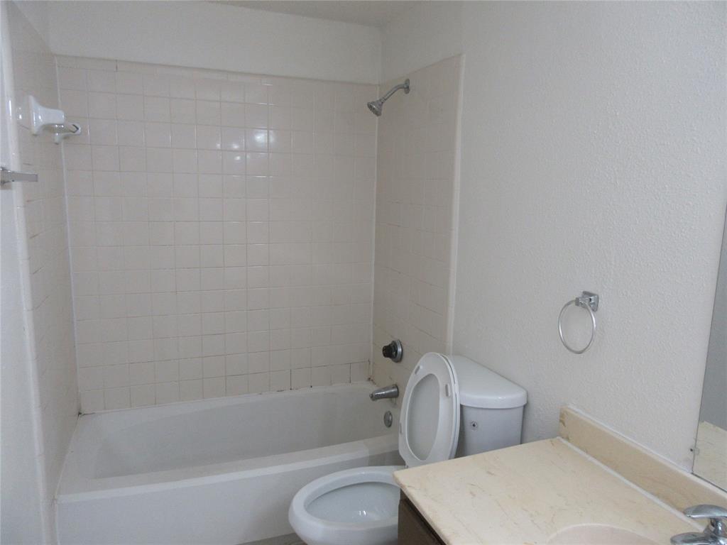 9737 Whitehurst Drive, Unit 39 Dallas, TX 75243 - Photo 5 of 5 a bathroom with a toilet and a bathtub