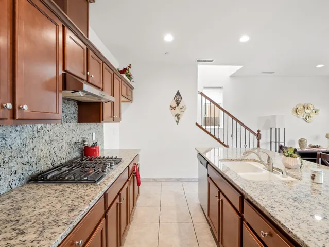 a kitchen with stainless steel appliances granite countertop a sink stove and cabinets