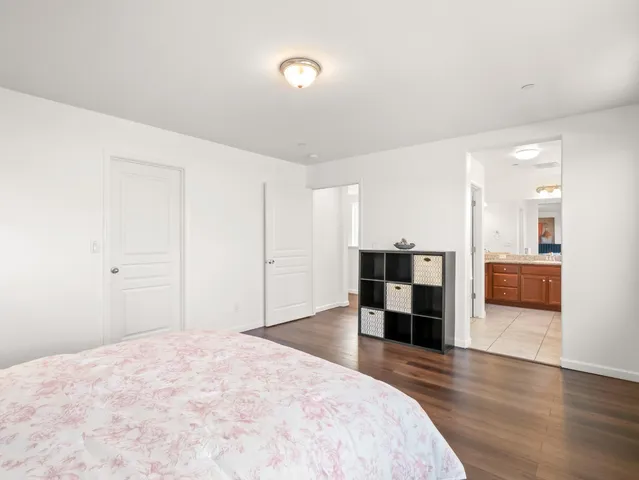 a large bedroom with a bed and a view of kitchen