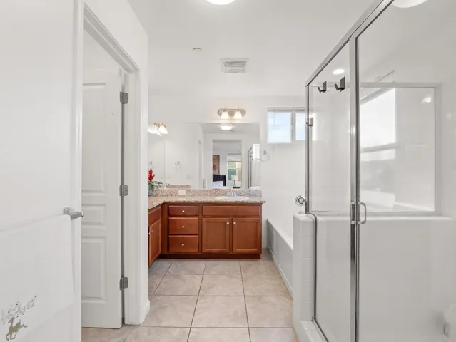 a bathroom with a granite countertop sink mirror and a bathtub