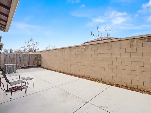 a backyard of a house with table and chairs
