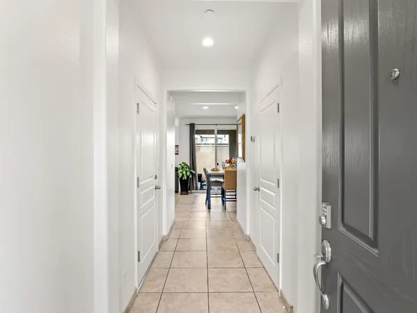 a living room with stainless steel appliances kitchen island granite countertop a table chairs and a sink