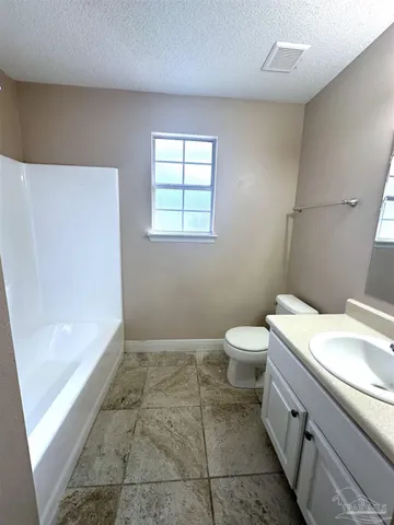 a bathroom with a granite countertop sink a toilet and a bathtub