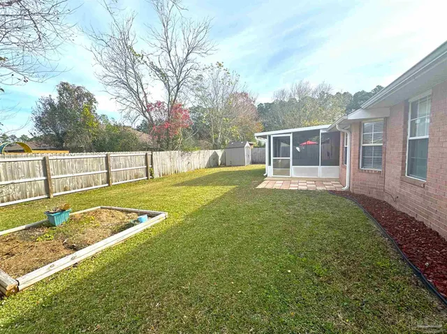 a view of a house with backyard and a tree