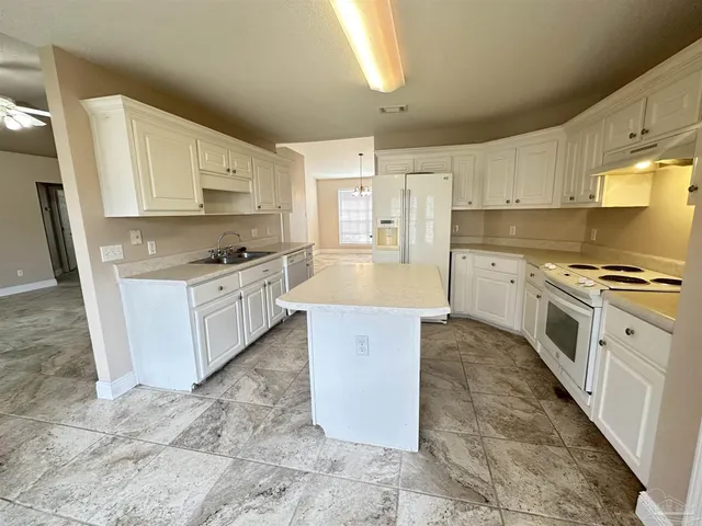 a large kitchen with stainless steel appliances granite countertop a stove a sink dishwasher and a refrigerator