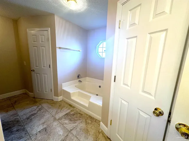 a spacious bathroom with a tub shower and a sink
