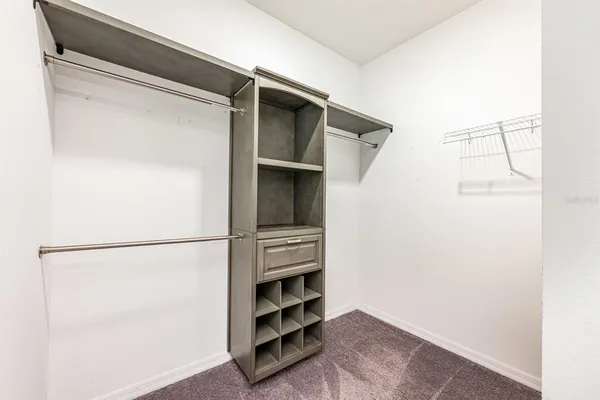 a view of walk in closet with empty racks
