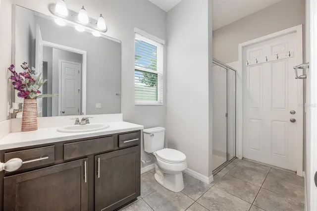 a bathroom with a granite countertop sink a toilet and a mirror