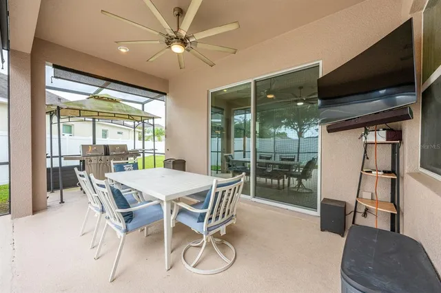 a dining room with furniture large windows and a chandelier