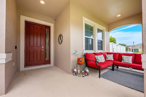 a front view of a house with a yard and potted plants