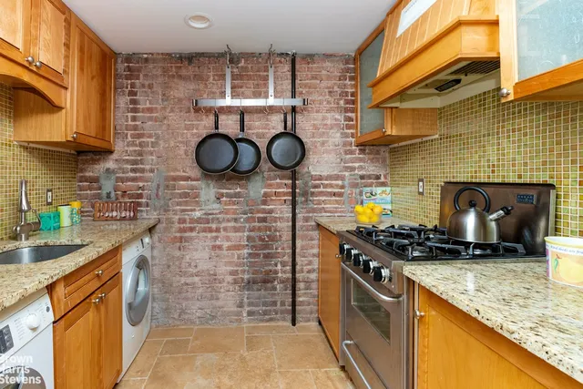 a kitchen with granite countertop a stove sink and cabinets