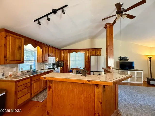 a kitchen with sink a counter top space appliances and cabinets