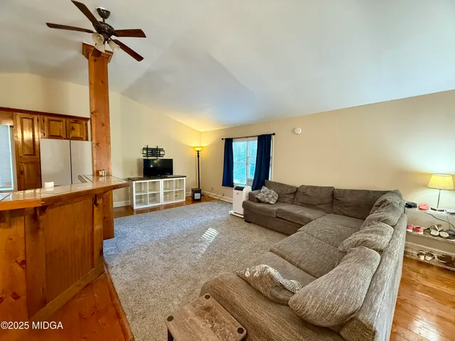a living room with furniture and a ceiling fan