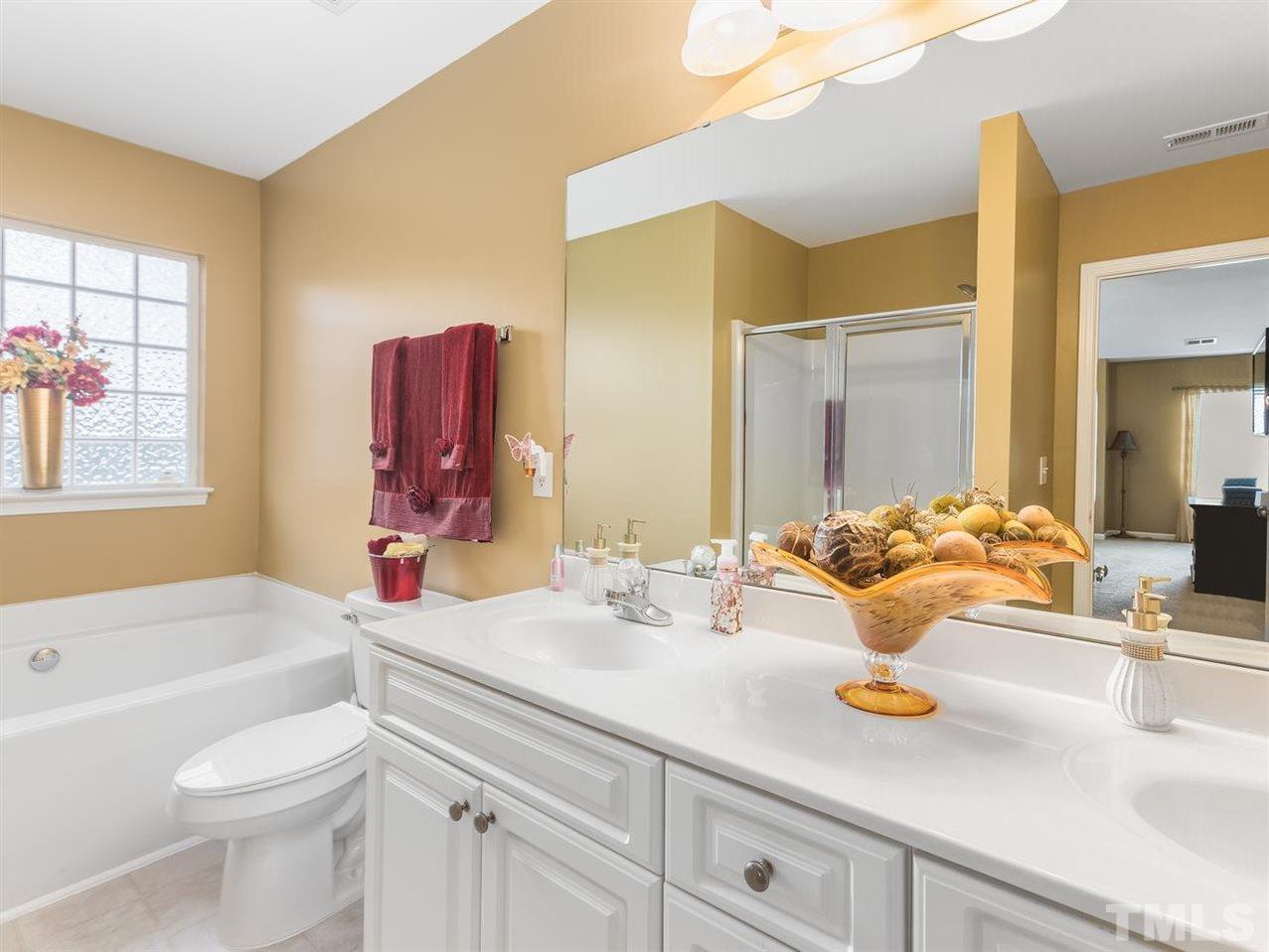 7021 Spanglers Spring Way Raleigh, NC 27610 - Photo 13 of 18 a bathroom with a sink a toilet and a large mirror
