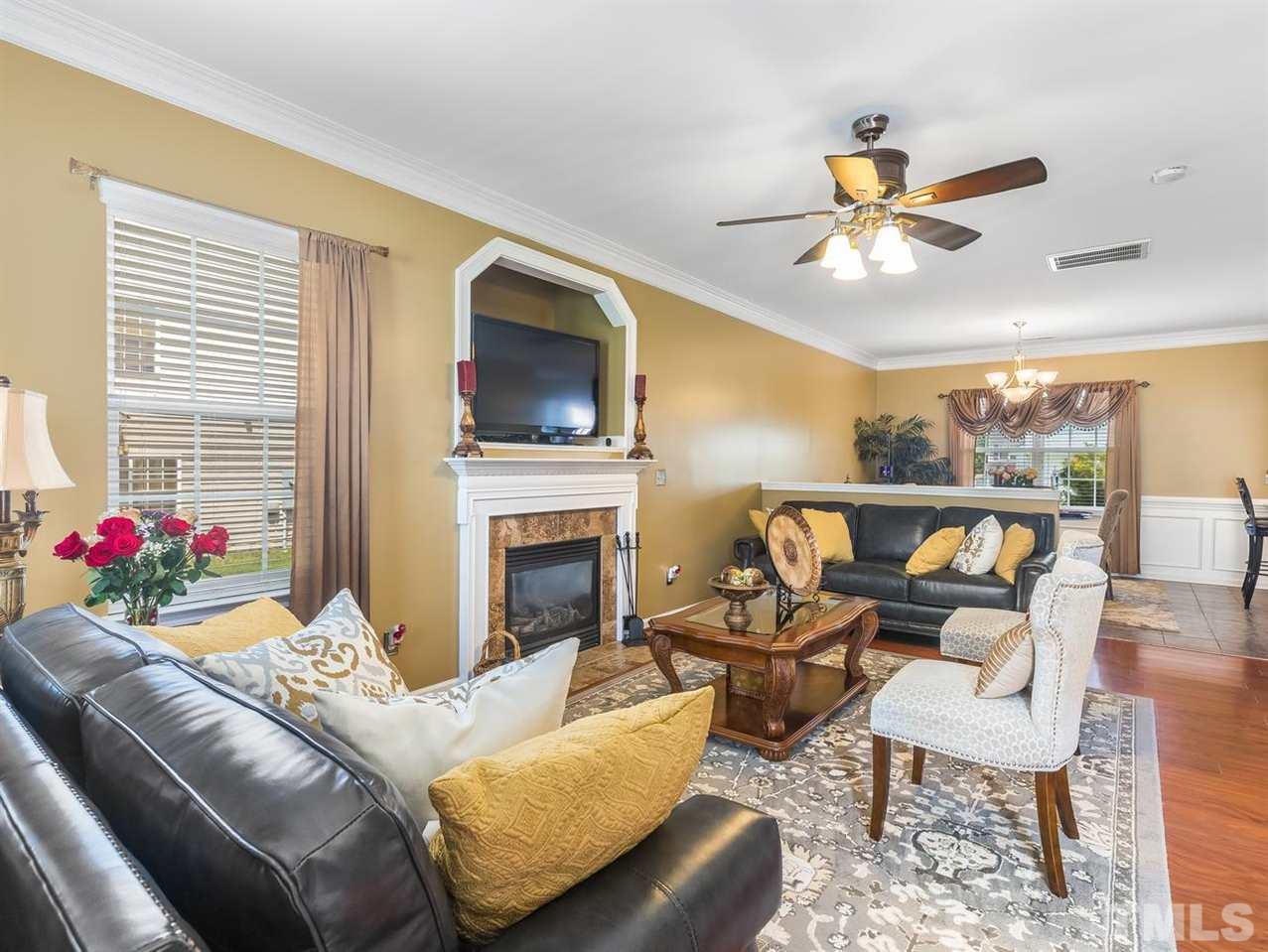 7021 Spanglers Spring Way Raleigh, NC 27610 - Photo 3 of 18 a living room with furniture a flat screen tv and a fireplace