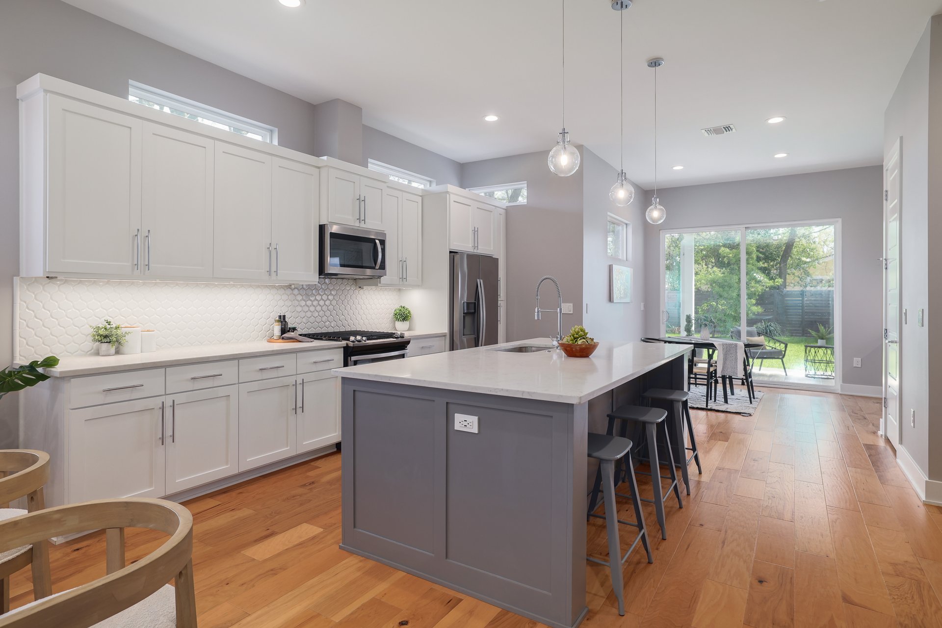 1103 Saucedo Street, Unit B Austin, TX 78721 - Photo 7 of 26 The large kitchen island serves as a natural gathering spot, topped with durable quartz and illuminated by recessed lighting