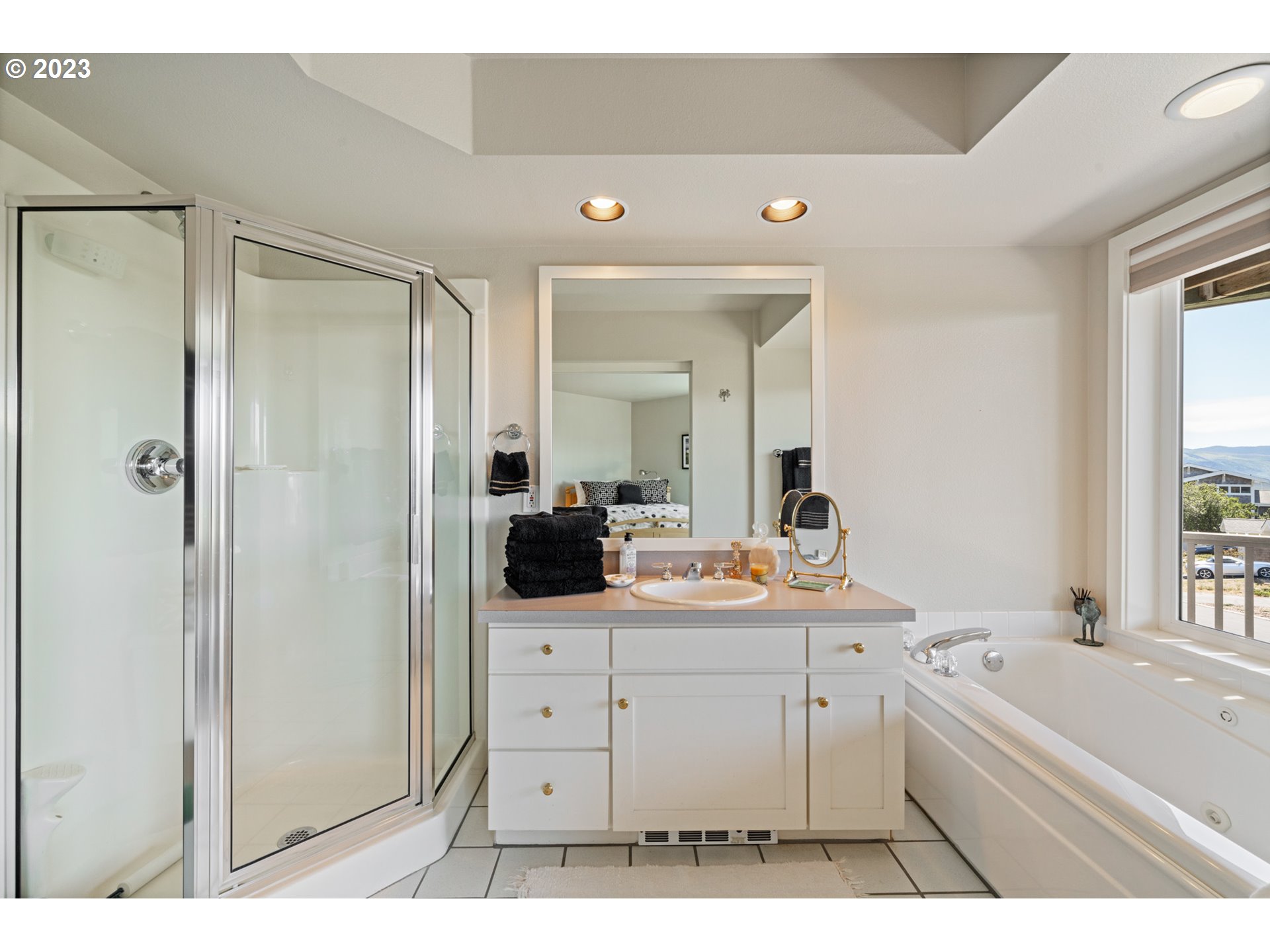 535 Capes Point Oceanside, OR 97141 - Photo 21 of 48 a bathroom with a double vanity sink a mirror a bathtub and shower