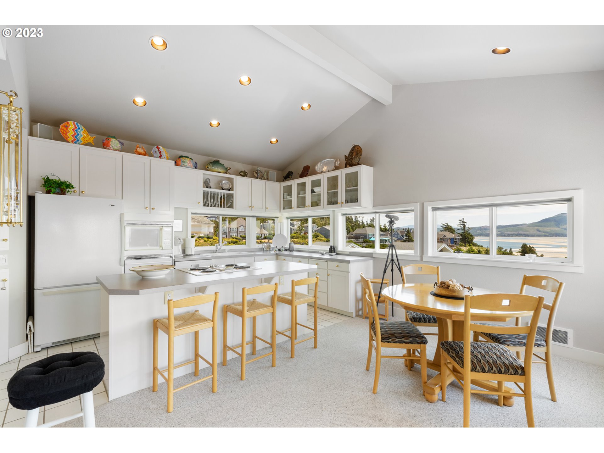 535 Capes Point Oceanside, OR 97141 - Photo 9 of 48 a kitchen with stainless steel appliances kitchen island granite countertop a table chairs and white cabinets