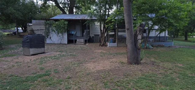 a view of a house with backyard and a tree