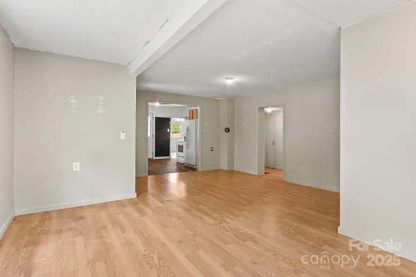 a view of empty room with wooden floor and window