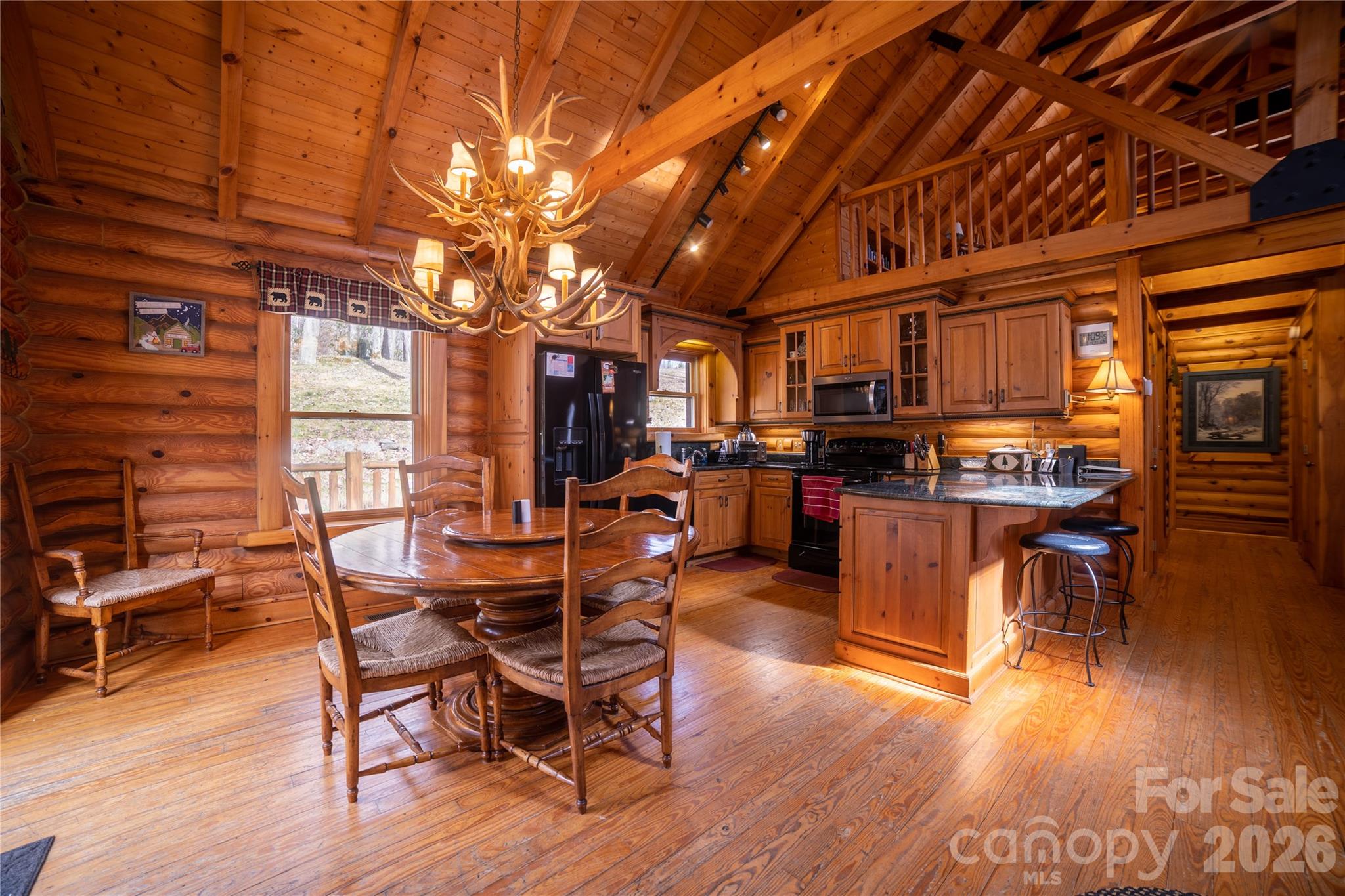 682 Rock House Road Hot Springs, NC 28743 - Photo 10 of 43 a view of a dining room with furniture window and wooden floor