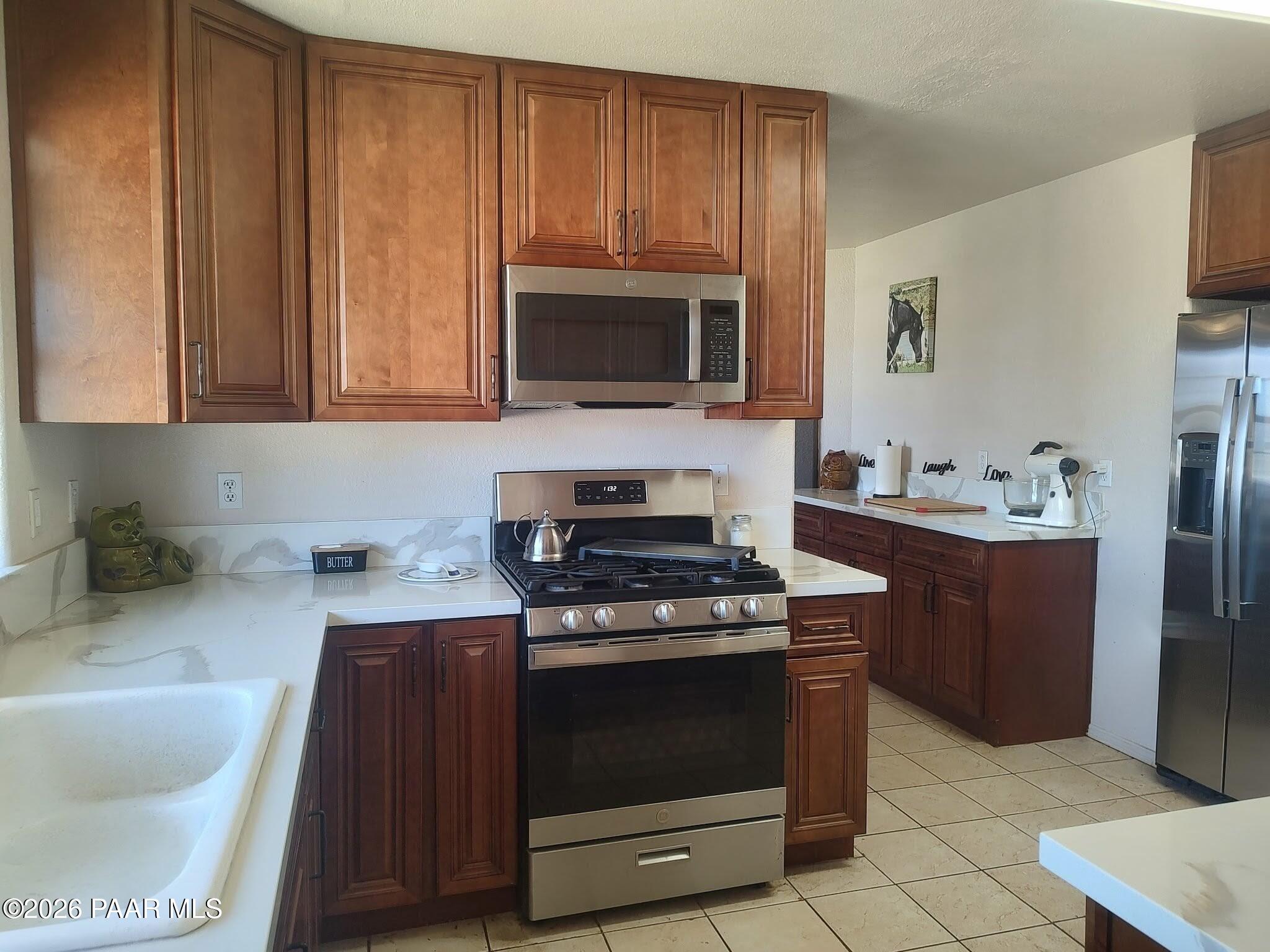 3980 West Rocky Road Paulden, AZ 86334 - Photo 11 of 32 a kitchen with stainless steel appliances a stove a microwave and a sink