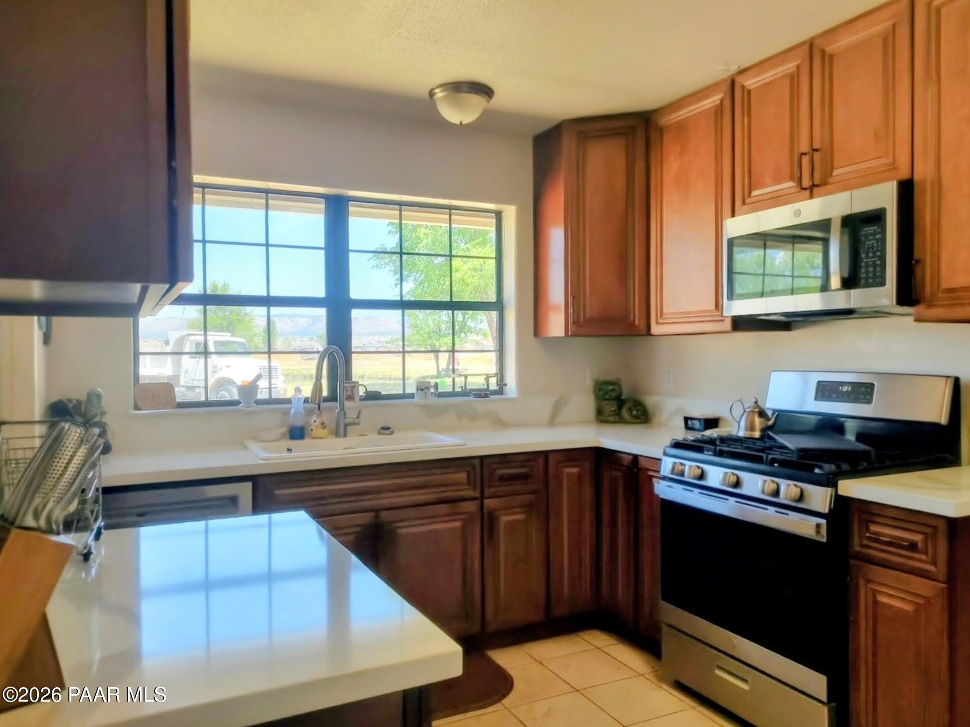 3980 West Rocky Road Paulden, AZ 86334 - Photo 9 of 32 a kitchen with stainless steel appliances granite countertop a sink stove and microwave