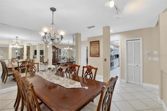 a room with stainless steel appliances lots of wooden furniture dining table and chairs