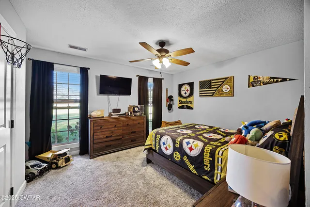 a bedroom with furniture and a flat screen tv