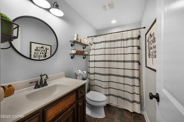 a bathroom with a sink mirror vanity and toilet