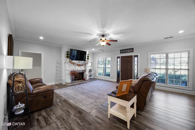 a living room with furniture a fireplace and a flat screen tv