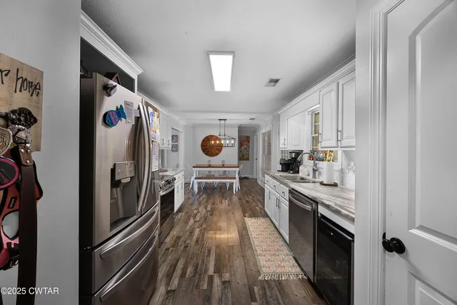a kitchen with stainless steel appliances granite countertop a refrigerator and a stove top oven