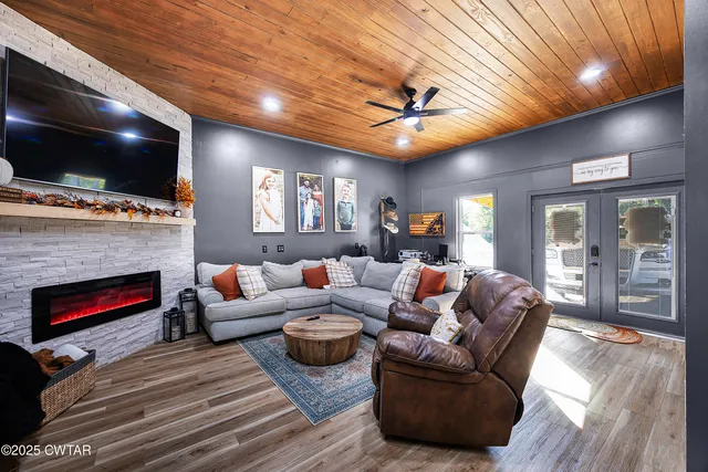 a living room with furniture a flat screen tv and a fireplace