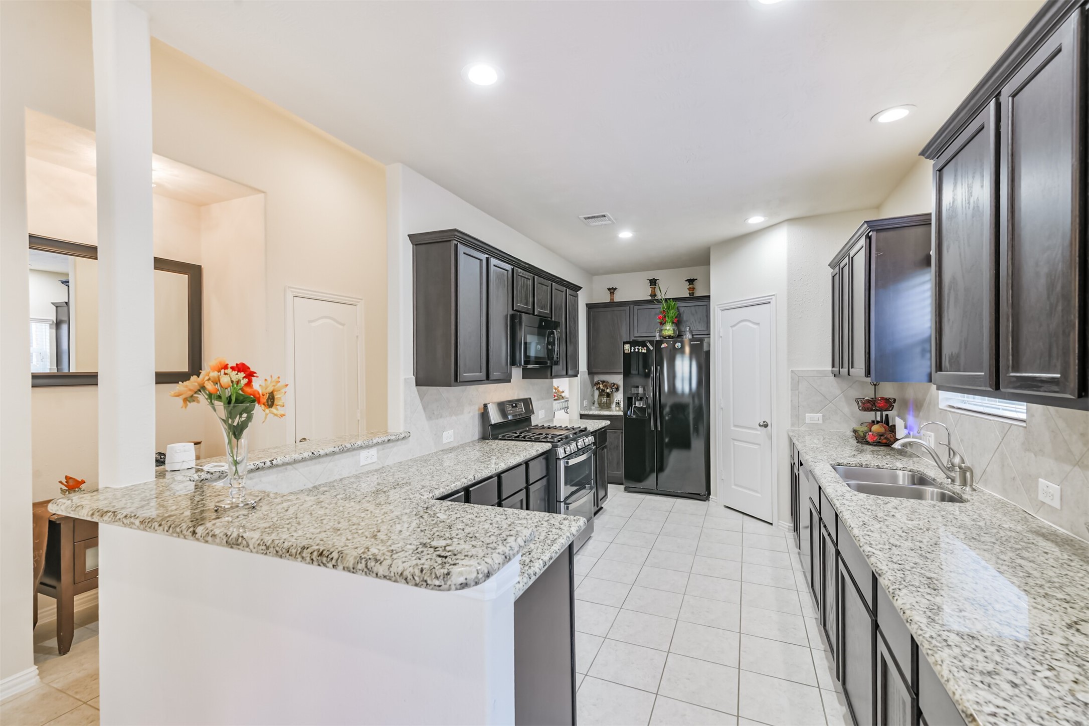 7527 Windsor Valley Lane Houston, TX 77049 - Photo 17 of 35 a large kitchen with granite countertop a sink counter top space and stainless steel appliances