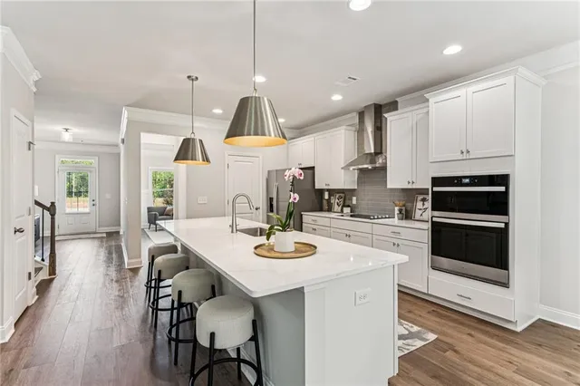 a kitchen with stainless steel appliances a stove a sink a stove a refrigerator cabinets and dining table