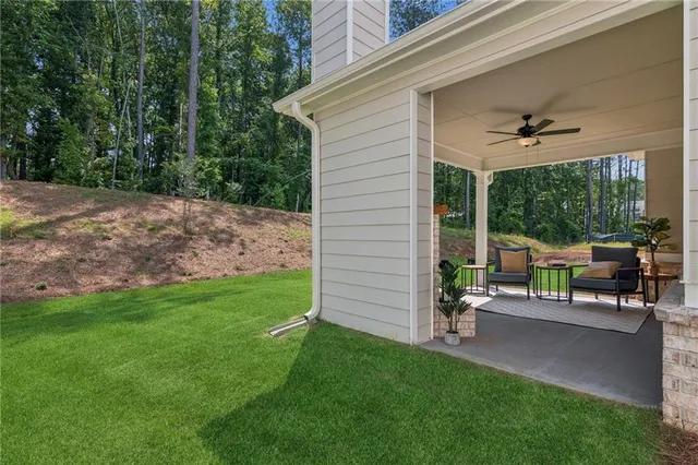 a view of a house with backyard and sitting area