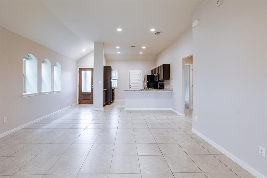 615 Stampede Road San Marcos, TX 78666 - Photo 23 of 26 The open-concept layout features a seamless transition from the living area to the kitchen, all set atop gleaming tile floors.