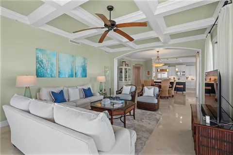 a living room with furniture a ceiling fan and a flat screen tv