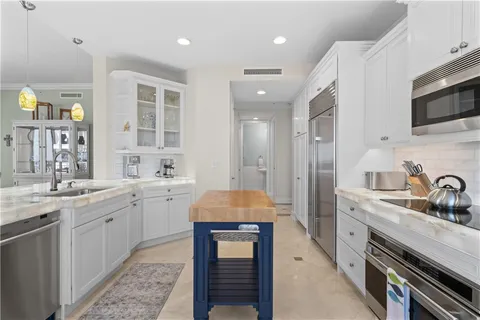 a kitchen with granite countertop a sink stainless steel appliances and cabinets
