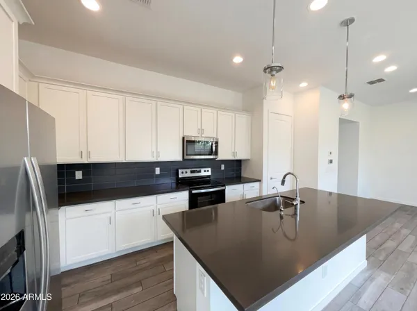 a kitchen with stainless steel appliances granite countertop a sink a stove and a refrigerator